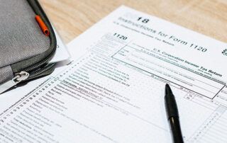 Tax Form on Table with Laptop Bag