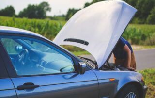 Broken Down Car with Man Under Hood