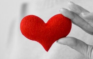 Hand holding red heart