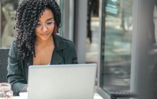 Woman on Computer Outside Café