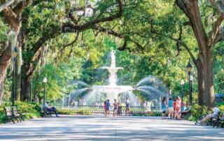 People Gathered Around Fountain in Park Summertime