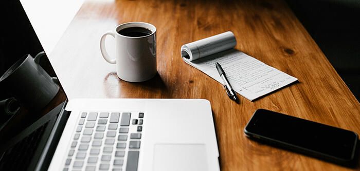 Computer, Coffee, Paper & Phone Sitting on Desk